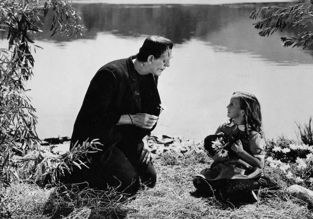 El monstruo de Frankenstein juega con una niña en la orilla de un lago